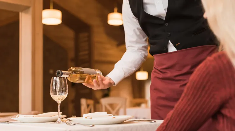 cropped-image-of-waiter-pouring-white-wine-into-gl-2023-11-27-05-01-28-utc.jpg